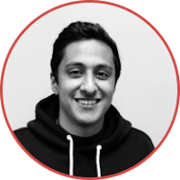 a black and white photo of a smiling man in a hoodie
