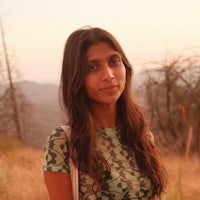 a woman in a camouflage shirt standing in a field